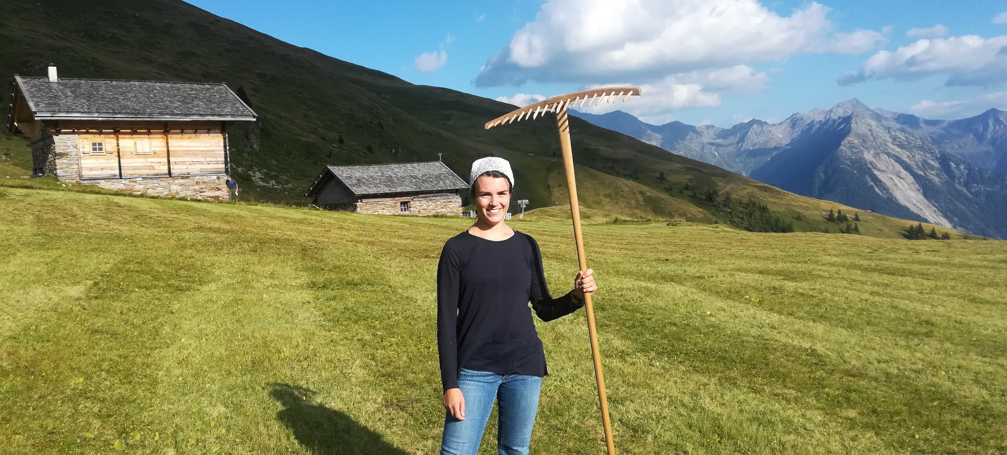 Freiwillige Helfer unterstützen Bergbauern bei der Arbeit auf steilen Almwiesen in Südtirol, um traditionelle Landwirtschaft zu erhalten